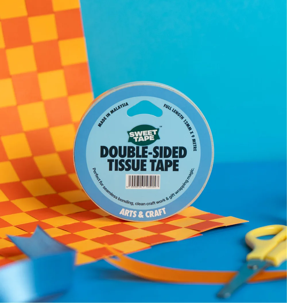 A roll of SweetTape double-sided tissue tape on a checkerboard cutout
